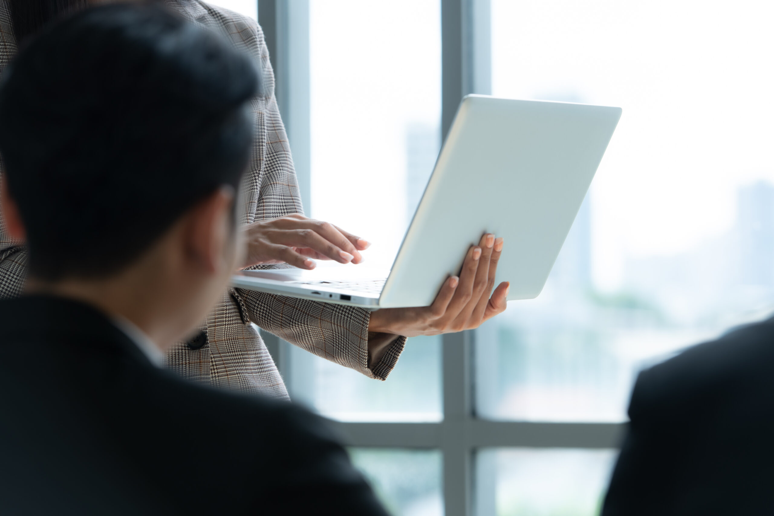 A group of young Asian entrepreneurs. Top Management is meeting to review stock investment data from the team in a meeting room with natural light